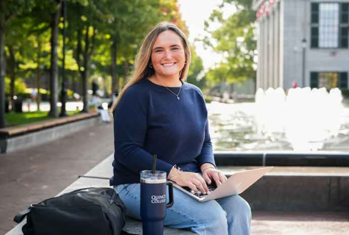 Current student holding a laptop
