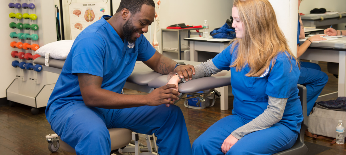 Physical Therapist Assistant student practicing with another student.