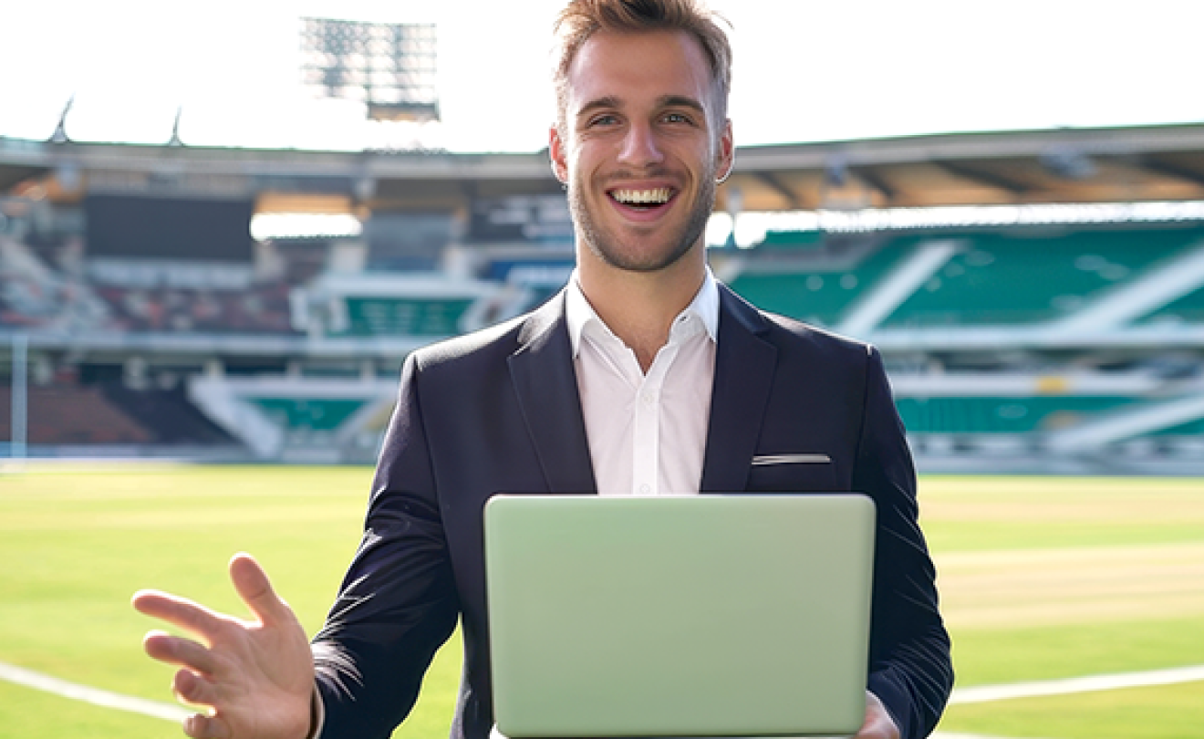 Young man holding a laptop in an open field