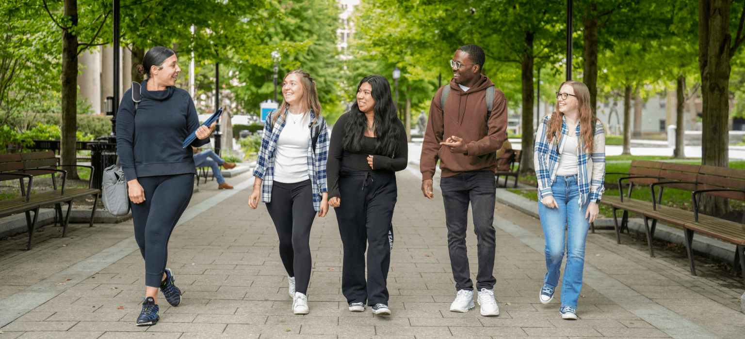 Students walking at the park in front of Quincy College