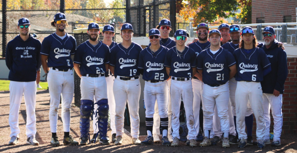 Quincy College Baseball team and their coaches posing together in uniform on a nice sunny day
